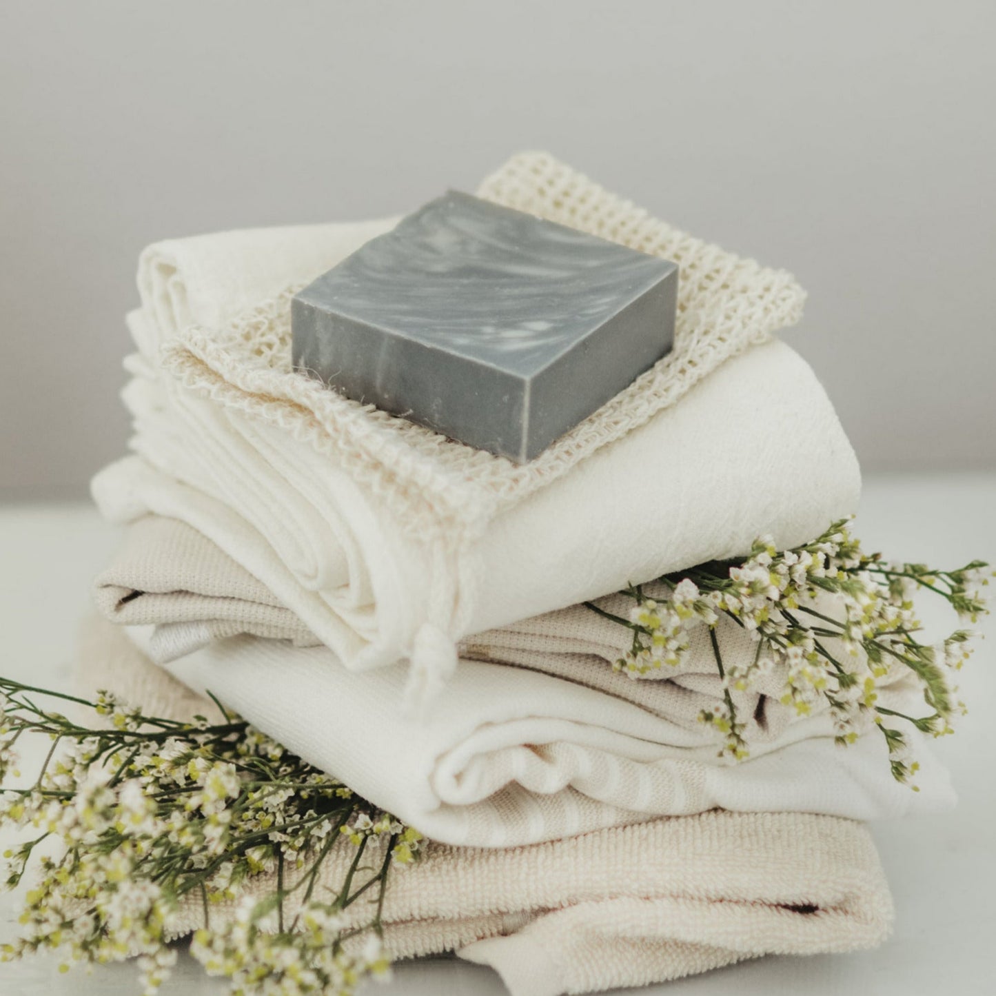 Black Amber + Clove soap on top of soap saver bag and towels