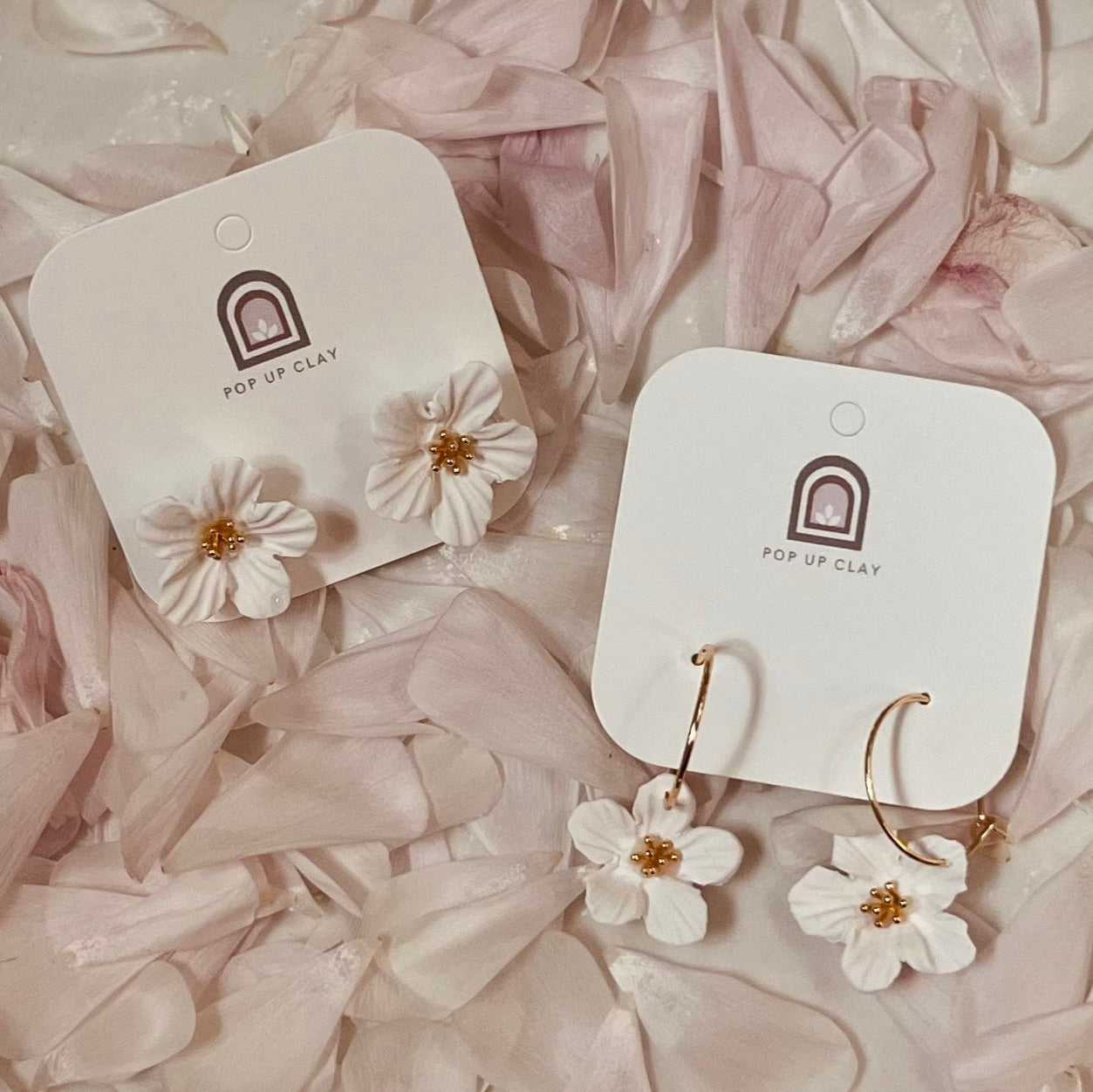Jasmine earrings on top of pink petals