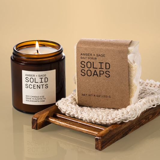 Candle and bar of soap on a wooden tray with a beige background